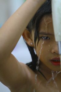 Close-up of young woman with hand in water