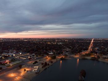 High angle view of illuminated buildings in city at sunset