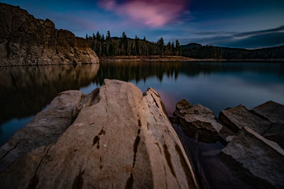 Scenic view of lake by mountains against sky