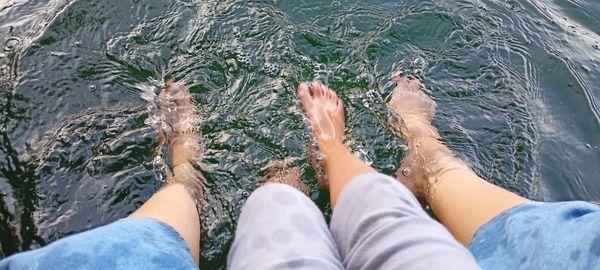 Low section of people legs in water