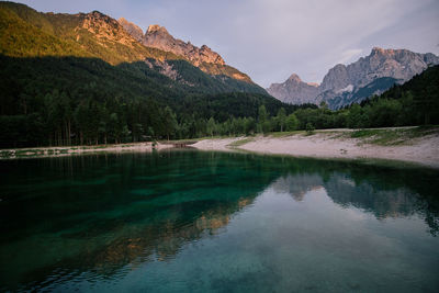 Scenic view of lake by mountains against sky