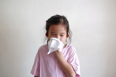 Portrait of a girl holding wall against white background