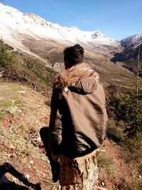 Rear view of woman walking on landscape against sky