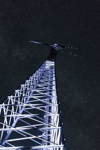 Low angle view of illuminated windmill against sky at night