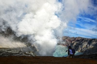 Rear view of woman against hot spring