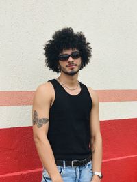 Portrait of young man standing against wall