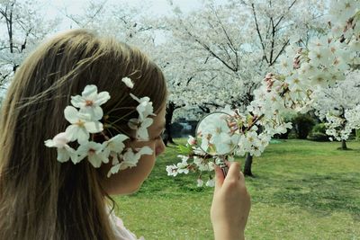 Portrait of woman with cherry blossom tree