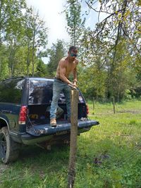 Shirtless man with arms raised