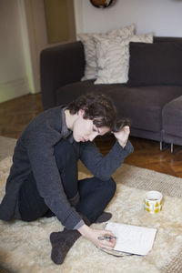 Rear view of boy sitting on sofa at home