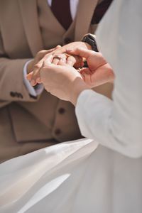 Midsection of woman holding wedding dress