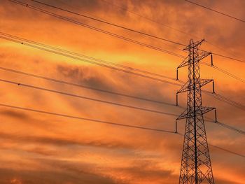 Low angle view of electricity pylon during sunset