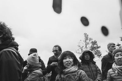 Rear view of people standing against sky