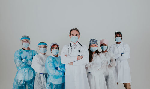 Doctors wearing mask standing against white background