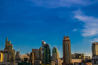 Modern buildings in city against blue sky