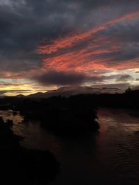 Scenic view of sea against dramatic sky during sunset