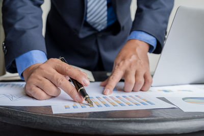 Midsection of man using laptop on table