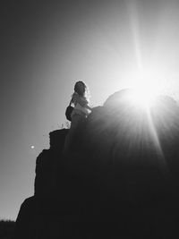 Low angle view of silhouette woman standing against sky during sunny day