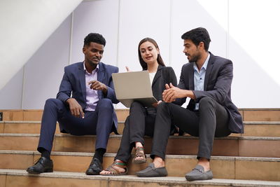 Business colleagues discussing while sitting on steps