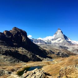 Scenic view of mountains against clear blue sky