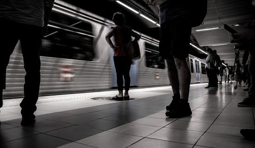 Low section of people standing on subway station platform