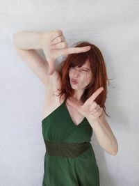 Beautiful young woman standing against white background