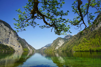 Scenic view of lake and mountains against clear blue sky