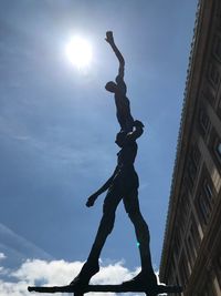 Low angle view of silhouette statue against sky