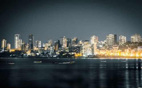 Illuminated cityscape against sky at night