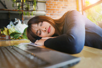 Portrait of girl lying on book at home