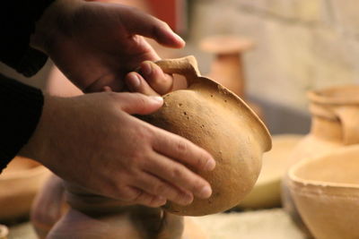 Cropped hands of man holding earthen pot