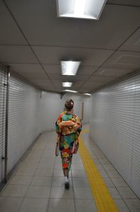 Rear view of man walking in corridor