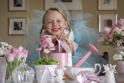 Portrait of little girl with objects on table