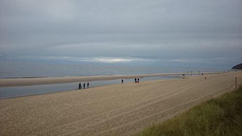 People on beach against sky