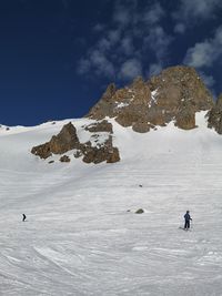 People on snowcapped mountain against sky