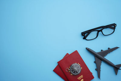 High angle view of eyeglasses on paper against blue background