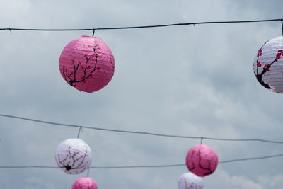 Low angle view of lanterns hanging against sky