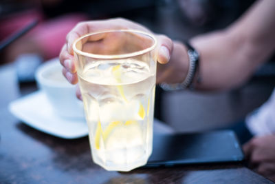 Cropped hand of woman holding drinking glass