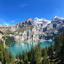 Scenic view of lake and mountains against blue sky