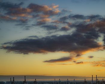 Silhouette people on beach against sky during sunset