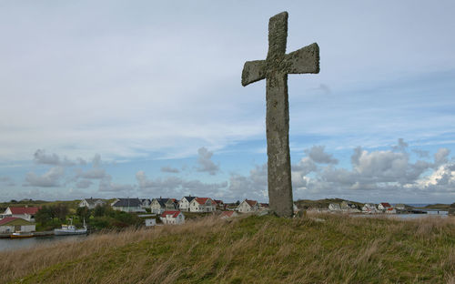 Cross on field against sky