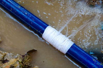 High angle view of water pipe on wood