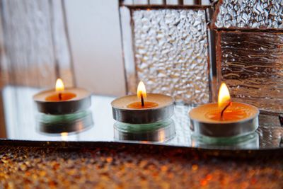 Close-up of illuminated candles on table