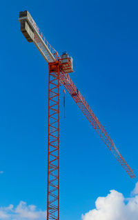 Low angle view of crane against clear blue sky