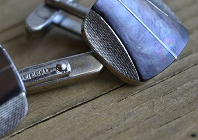 High angle view of cuff links on wooden table