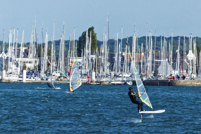 Sailboats in sea against sky