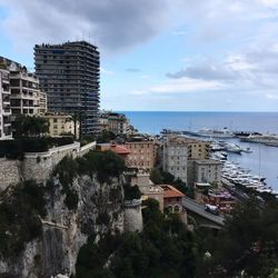 Cityscape by sea against sky