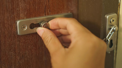 Close-up of human hand holding door