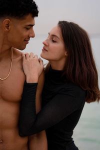 Portrait of young couple standing at the beach