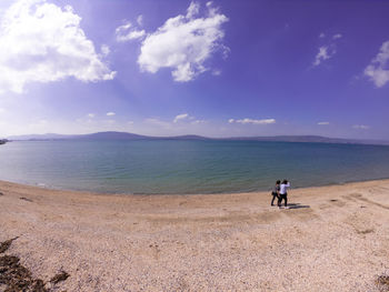 Men on beach against sky