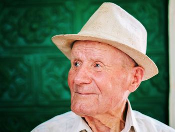 Close-up of thoughtful senior man wearing hat